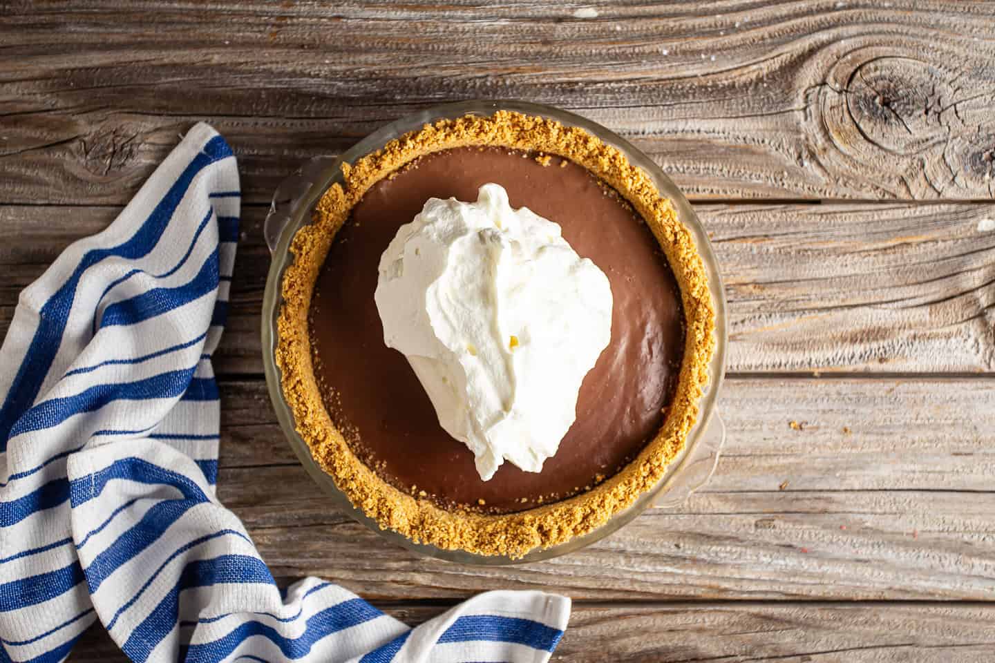 Topping chilled chocolate pudding pie with homemade whipped cream.