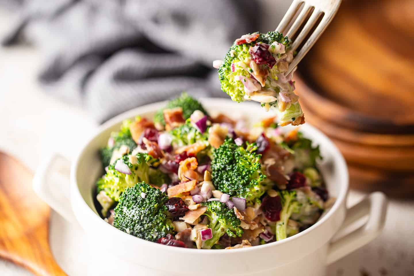 Taking up a forkful of broccoli salad with bacon.