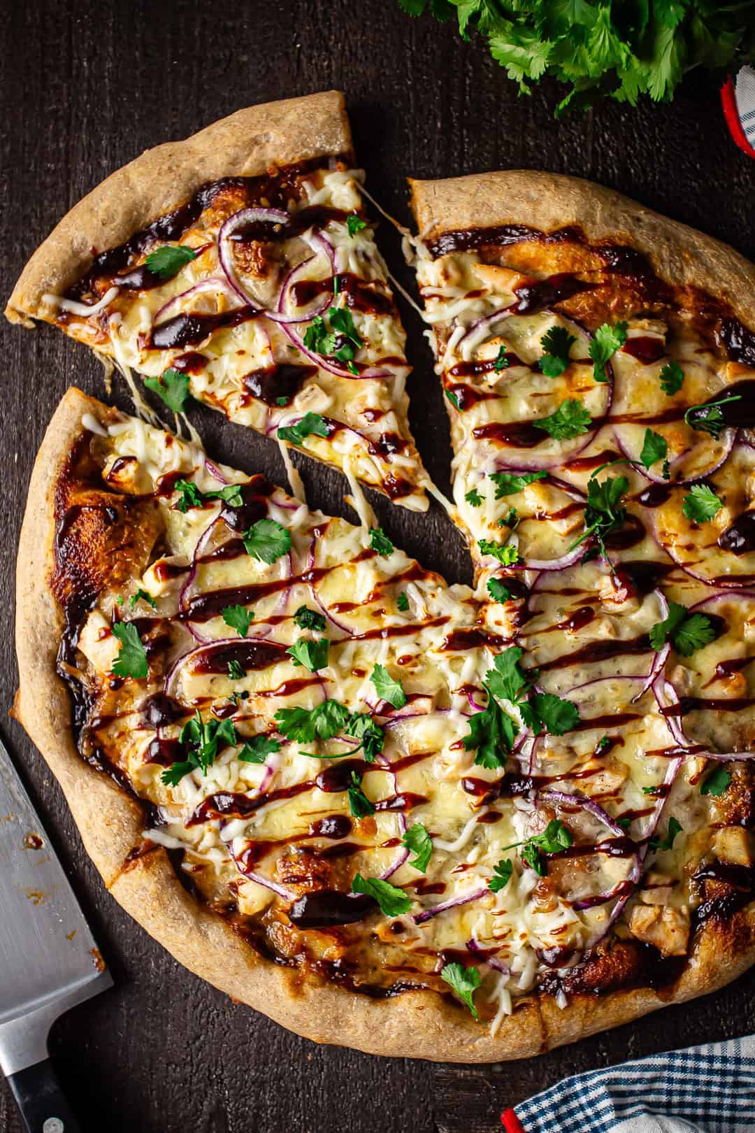 Barbecue chicken pizza Dominoes copycat recipe, with a kitchen knife and a bunch of fresh cilantro in the background.