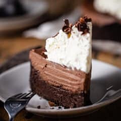 A tall slice of Mississippi mud pie on a white ceramic plate.