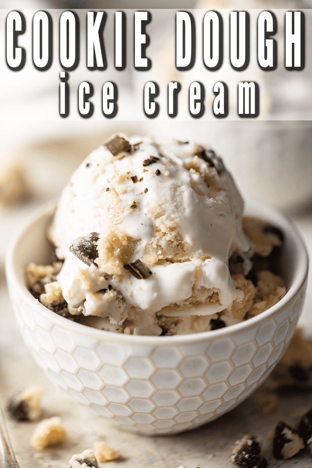 Chocolate chip cookie dough ice cream served in a textured bowl with extra cookie dough on top.