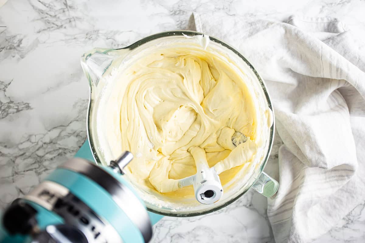 Cream cheese pound cake batter in a large glass mixing bowl.