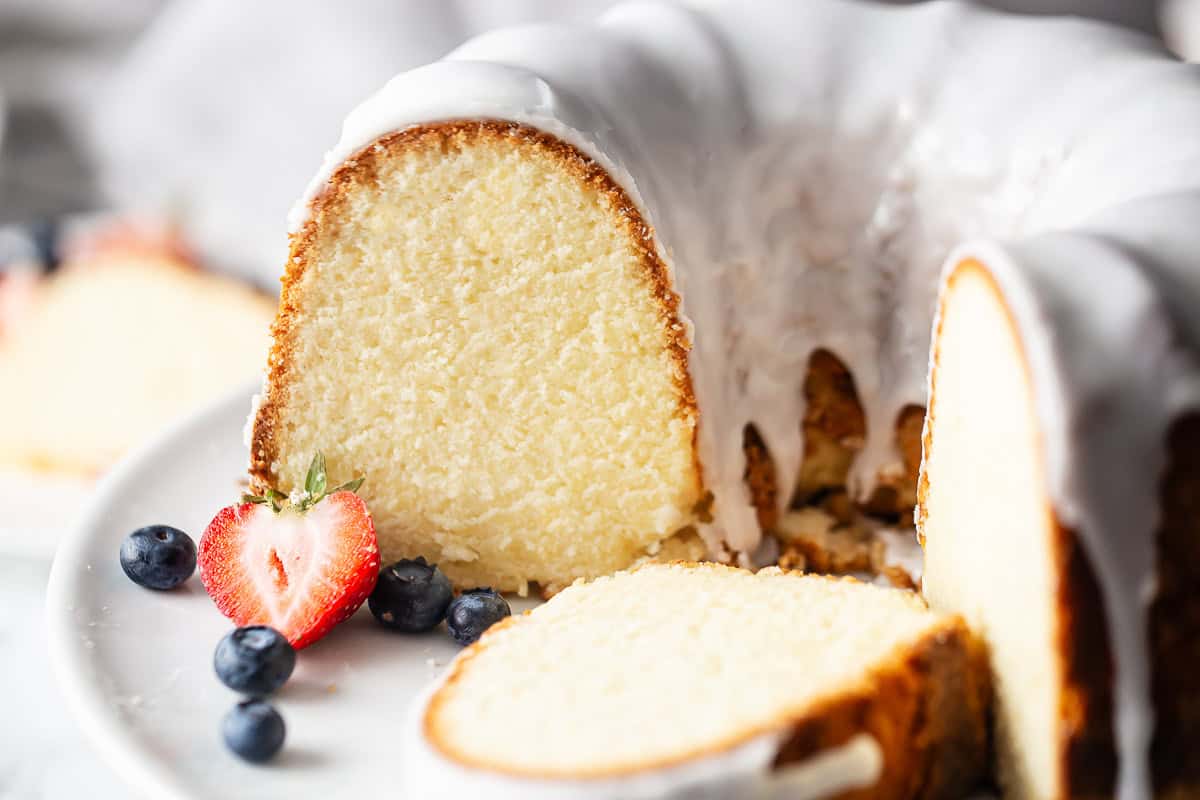 Pound cake recipe using cream cheese, baked in a bundt pan and garnished with fresh berries.