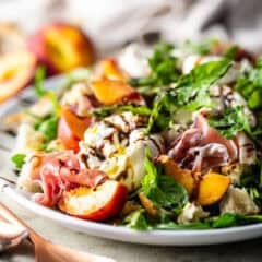 Peach salad presented on a white oval ceramic platter.