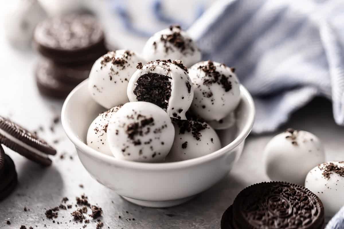 oreo truffle balls in a white bowl topped with oreo crumbs.