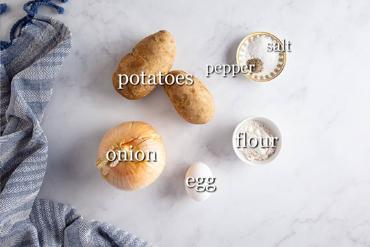 Ingredients for potato pancakes in separate containers on a white background.