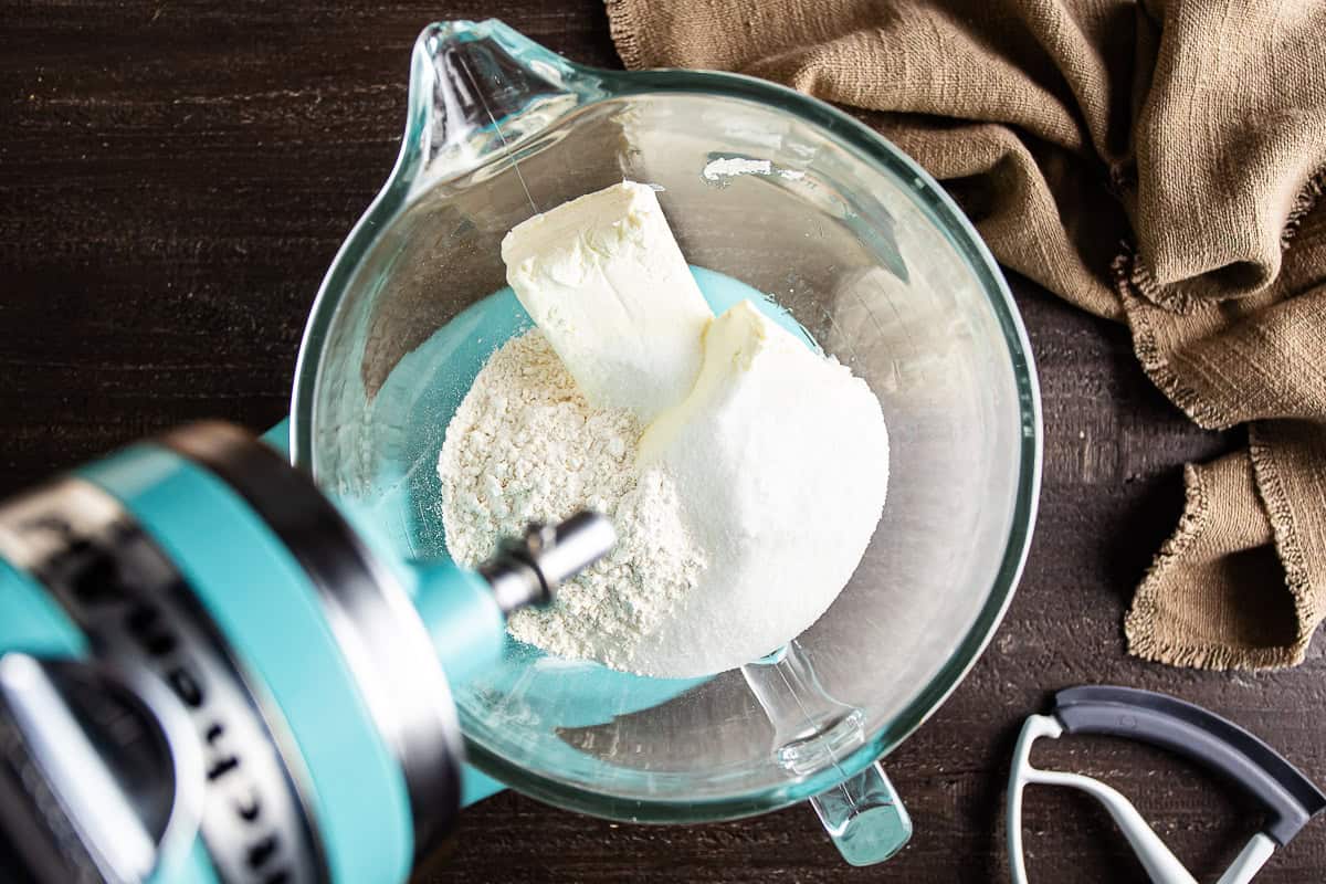 Cream cheese, sugar, flour, and salt in a mixing bowl before being mixed for Basque cheesecake.