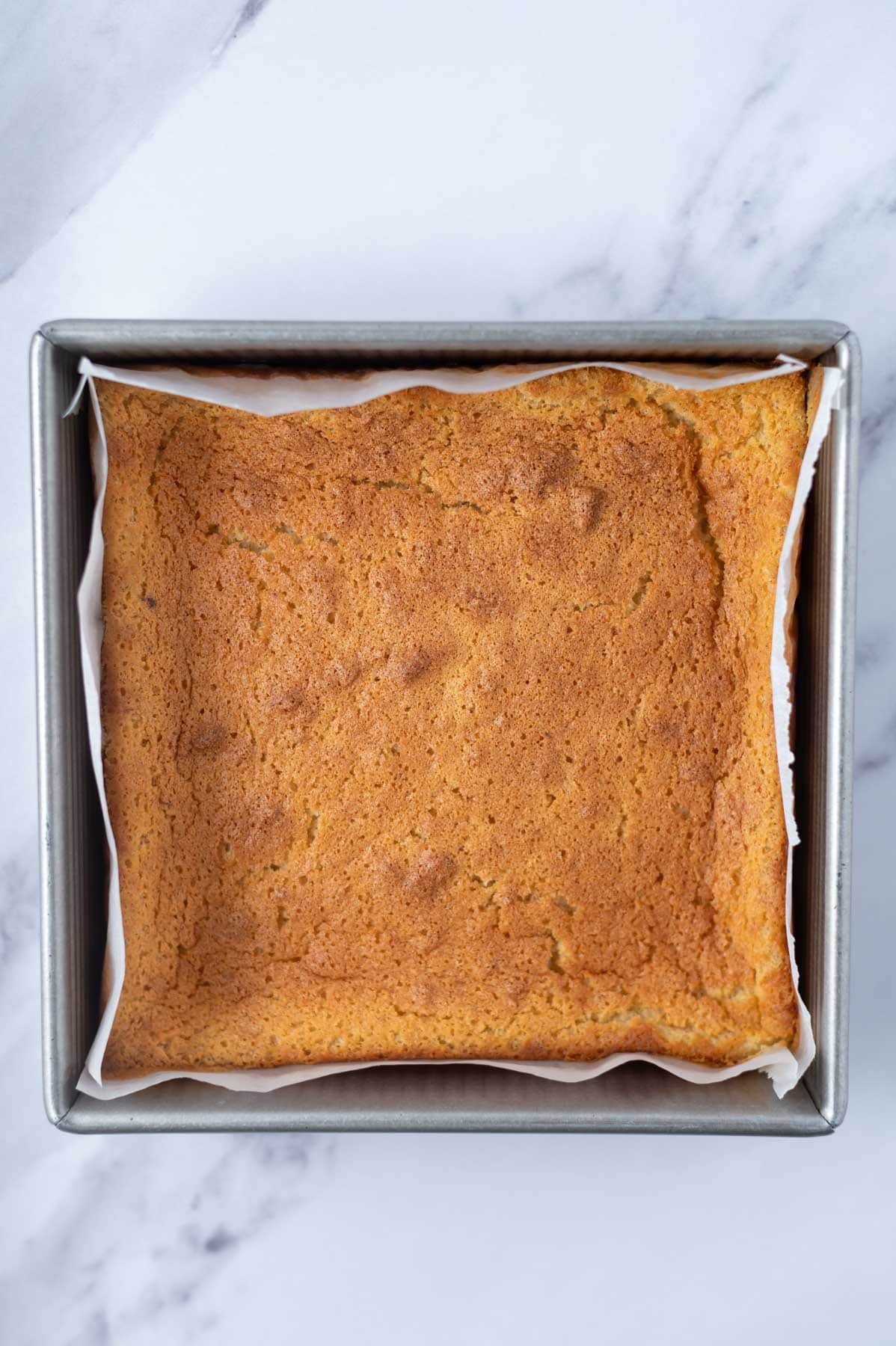 baked magic custard cake in a parchment lined baking pan
