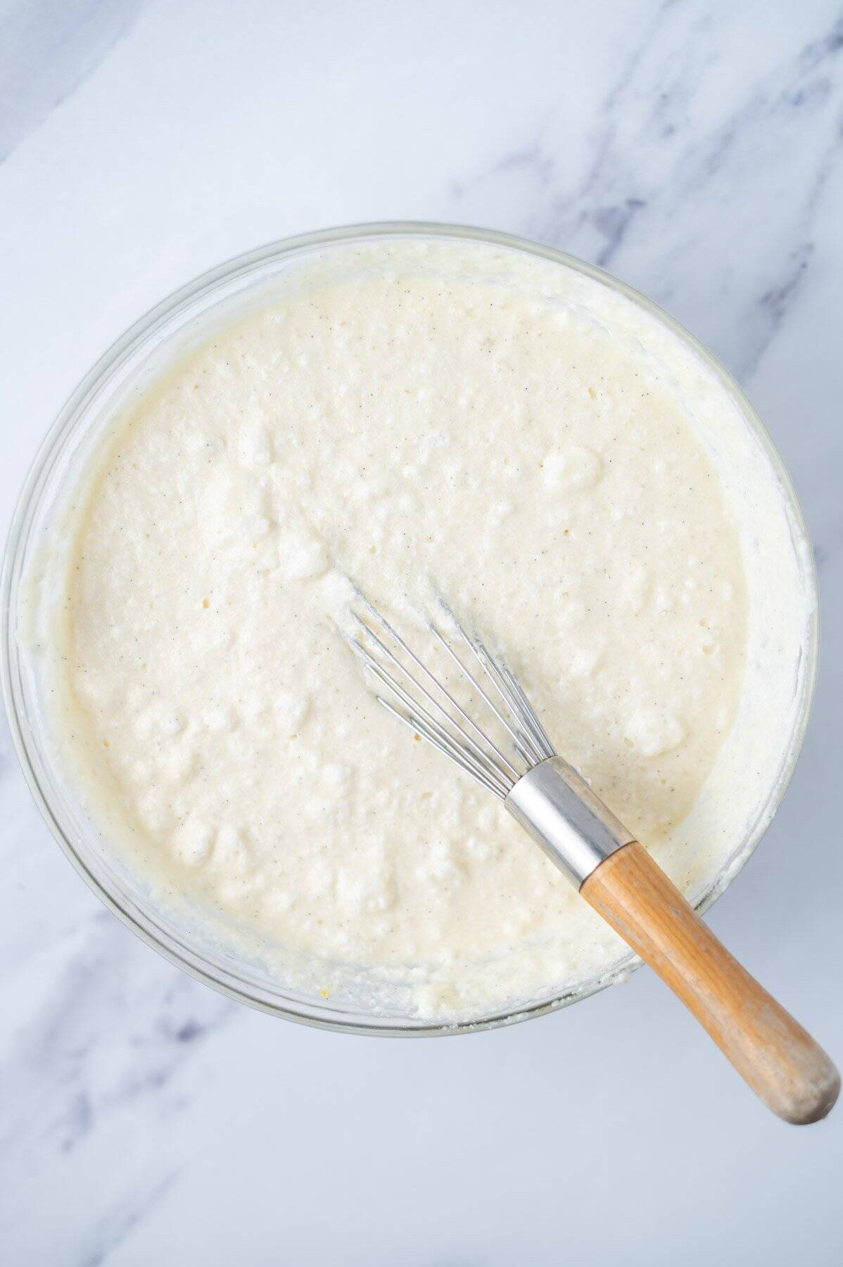 cake batter in a glass bowl with a whisk