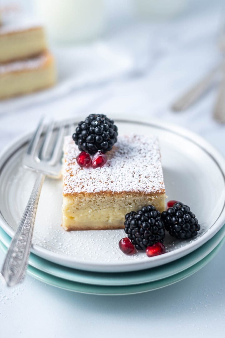slice of cake on a plate with a fork and fresh berries