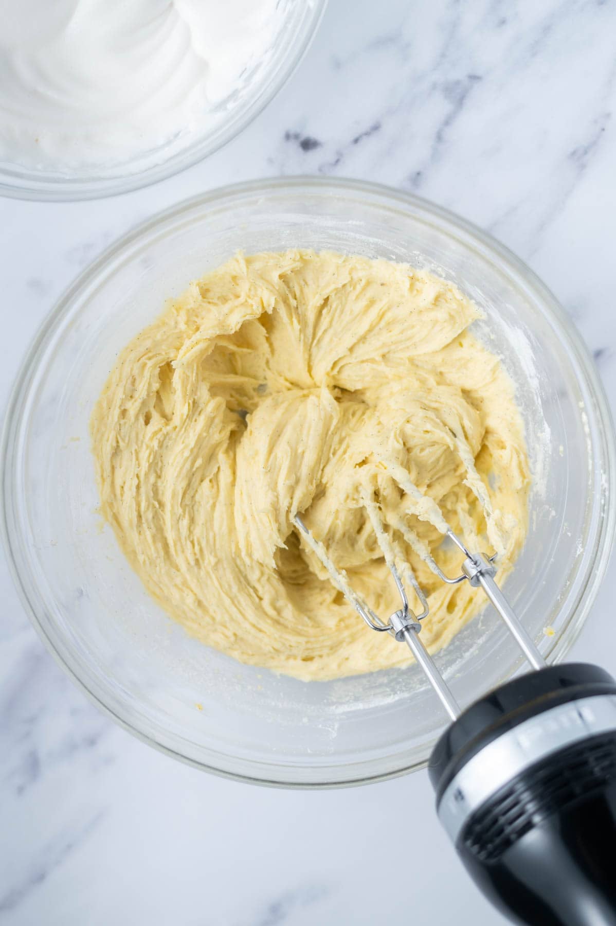 cake batter after flour has been added in a glass bowl