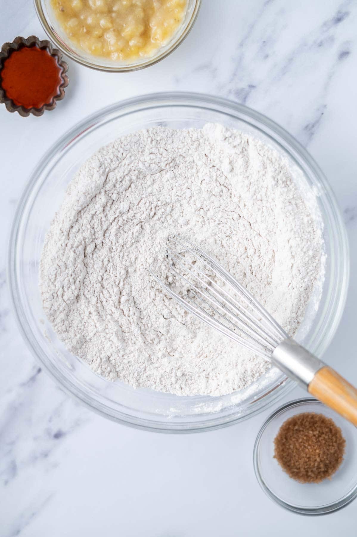 flour, baking powder, cinnamon and salt whisked together in a glass bowl with a whisk