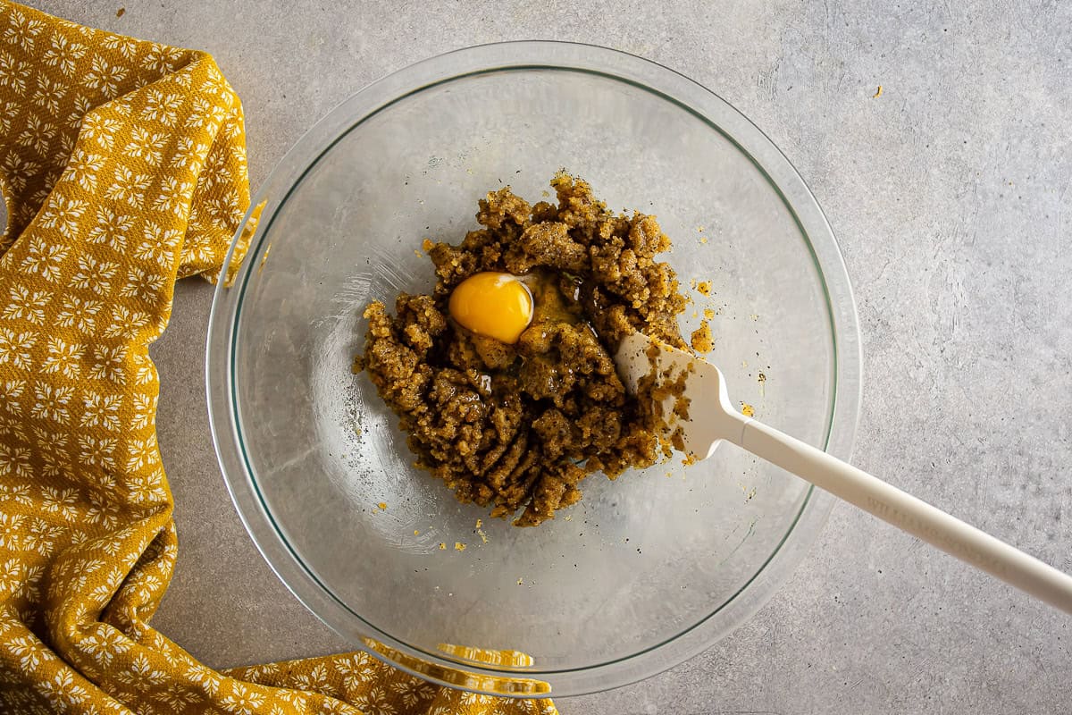 An egg yolk being added to the sugar mixture for black sesame earl grey cookies.
