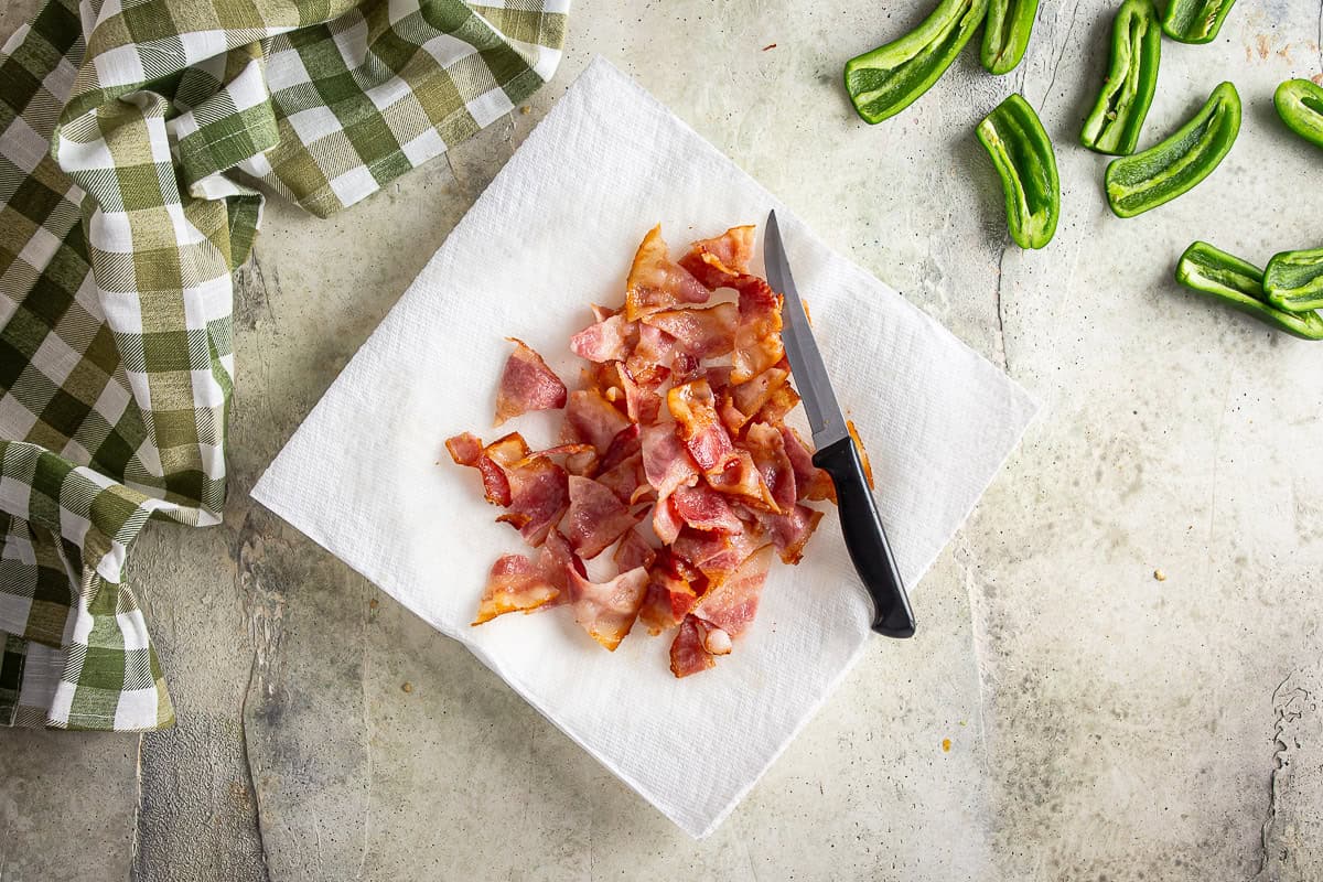 Partially cooked bacon after being cut into bite-sized pieces.