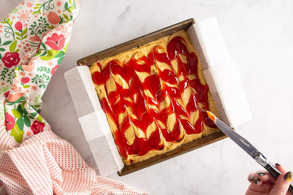 Strawberry jam swirled into the blondie batter before being baked.