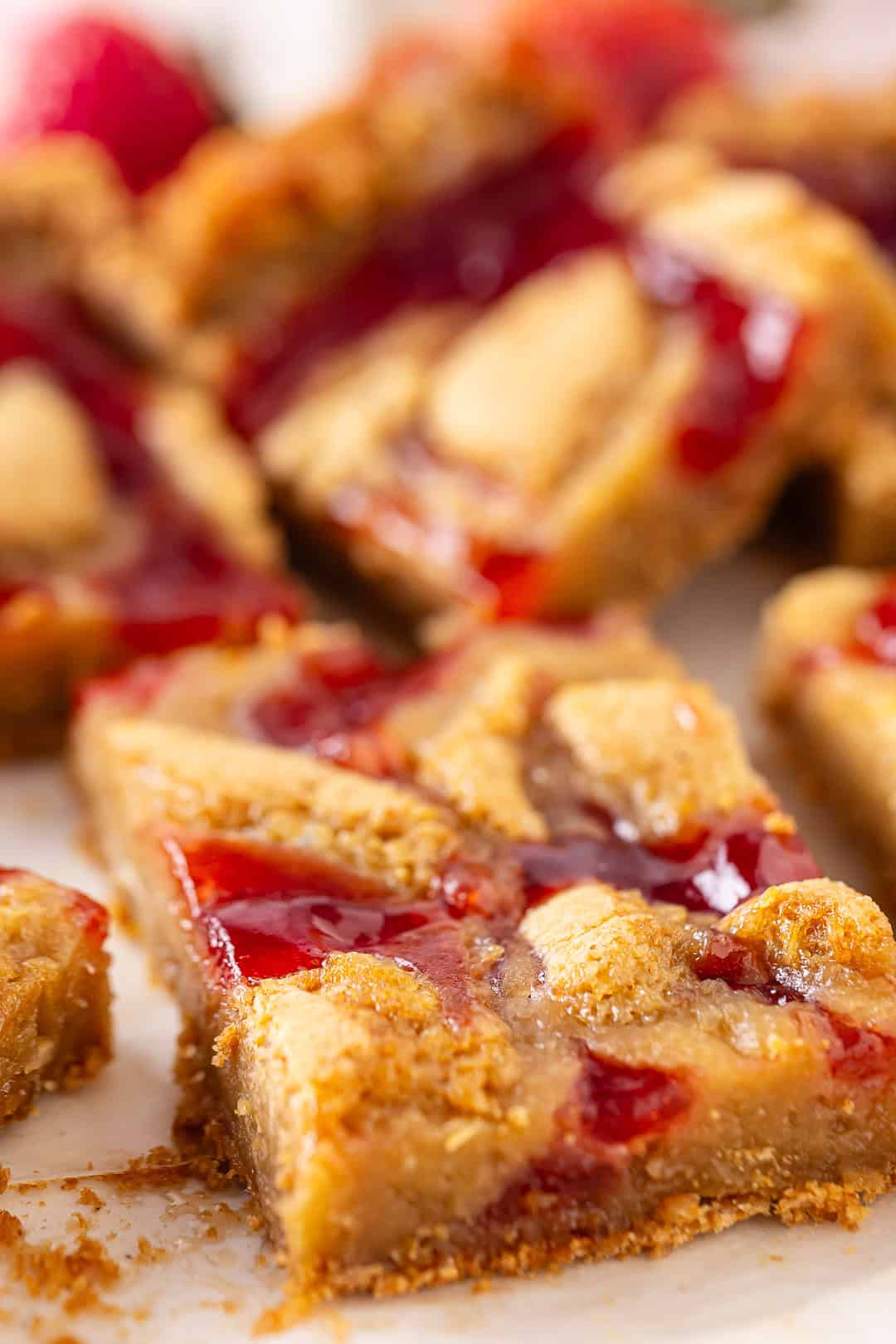 Berry blondies cut into squares with fresh strawberries in the background.
