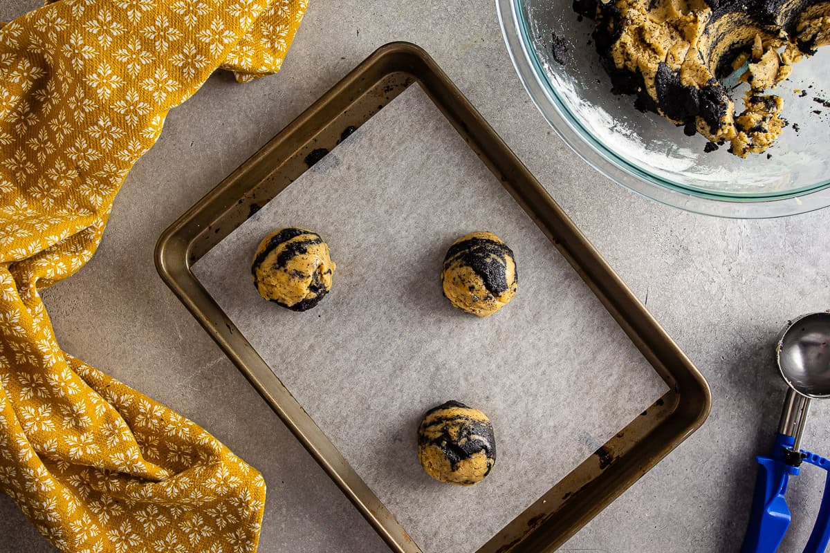 Earl grey cookie dough on a parchment-lined baking sheet before being baked.