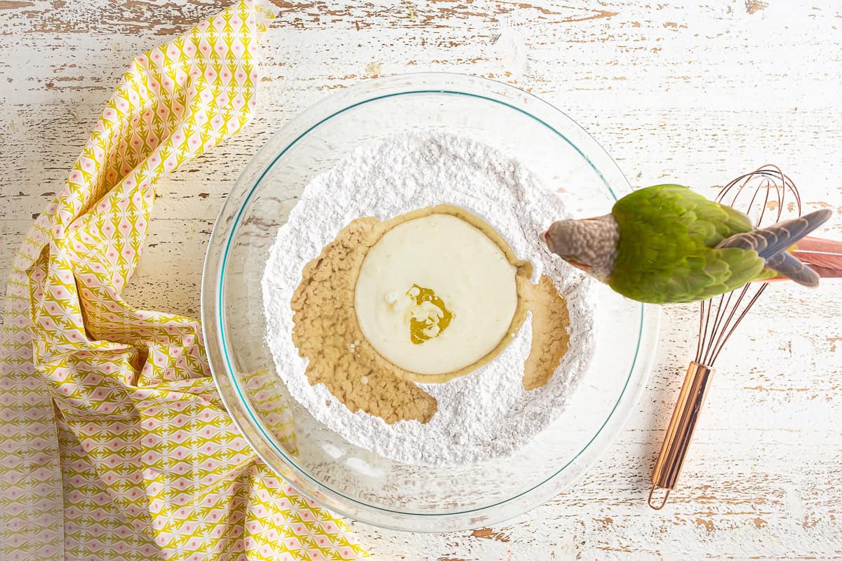 Adding liquid ingredients to the dry ingredients for a strawberry matcha loaf.