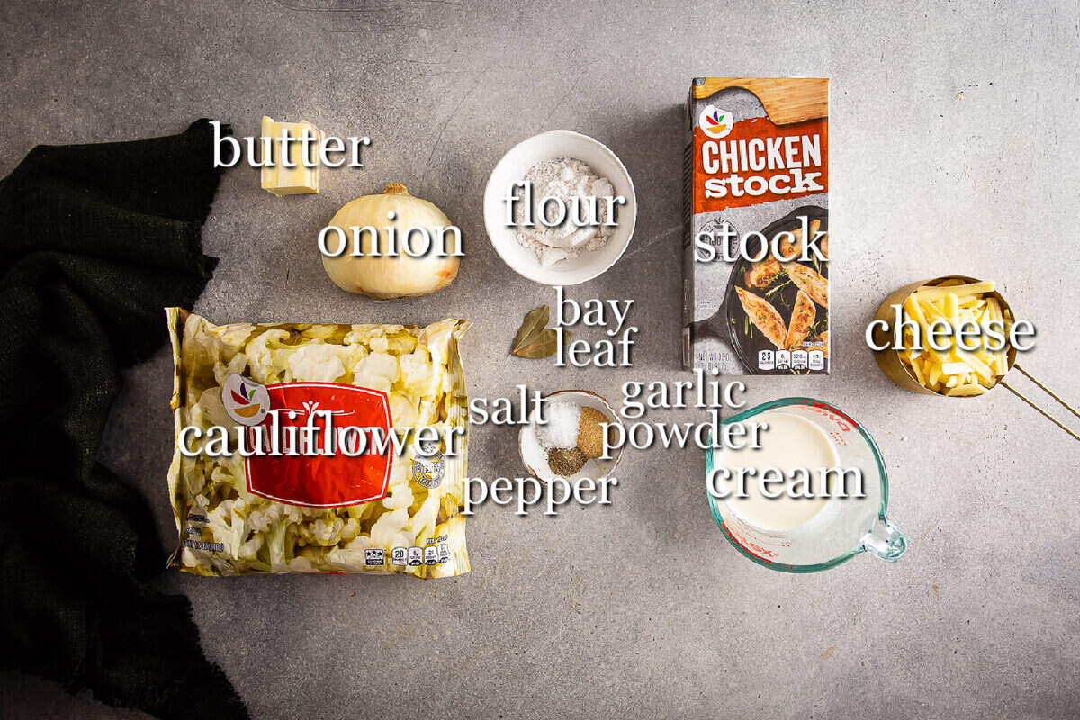 Ingredients for cauliflower soup in separate containers on a gray background.
