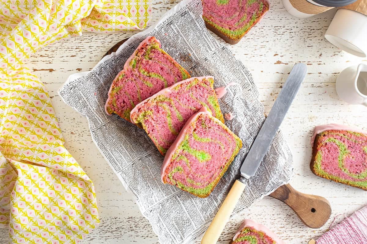 A sliced strawberry matcha loaf with a knife next to the slices.