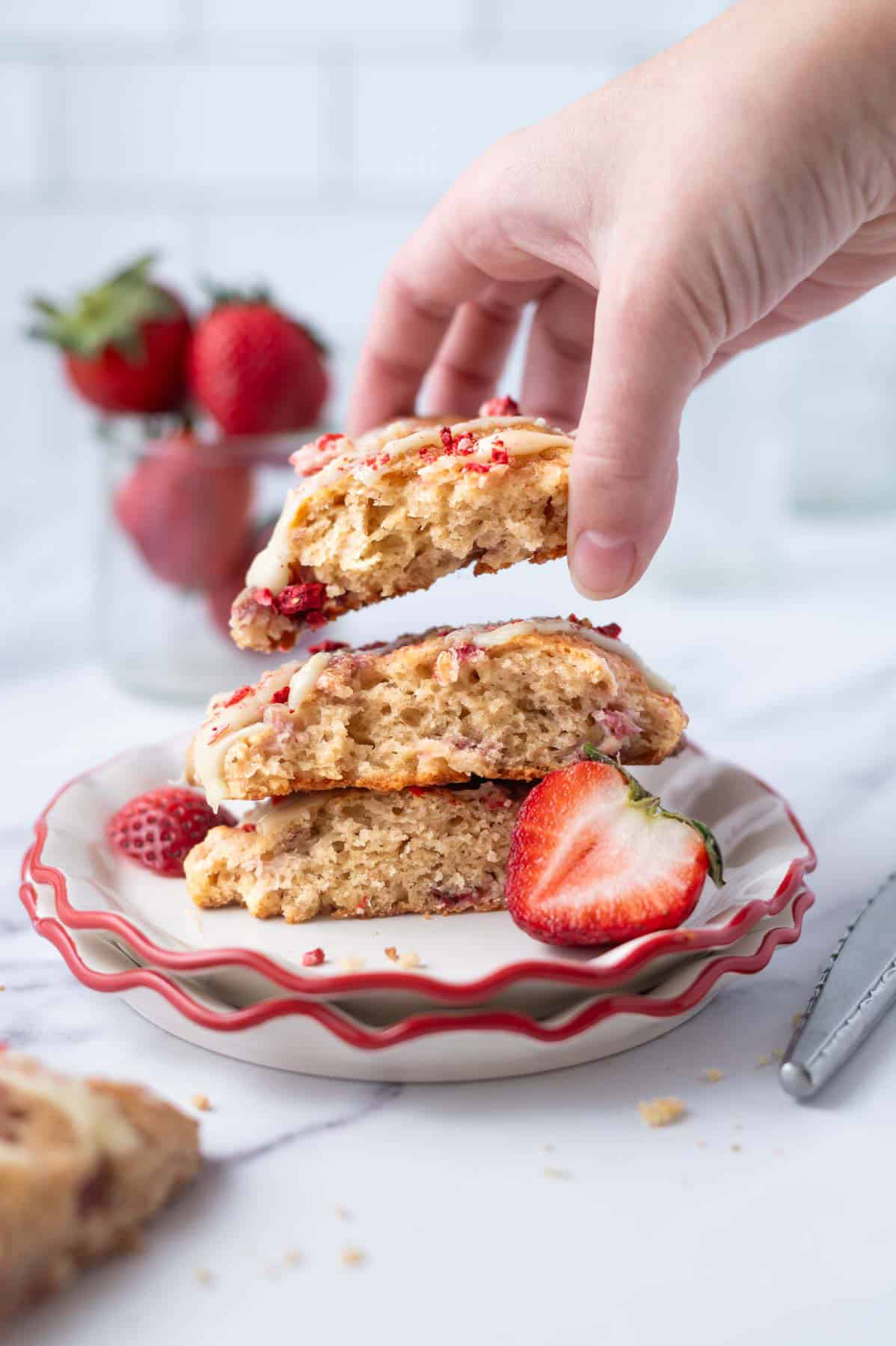 hand grabbing a scone from a plate