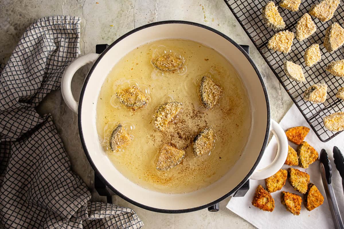 Frying breaded pieces of eggplant for eggplant parmesan pizza.