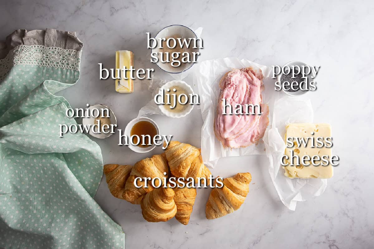 Ingredients for hot ham and cheese croissant sandwiches in separate containers.