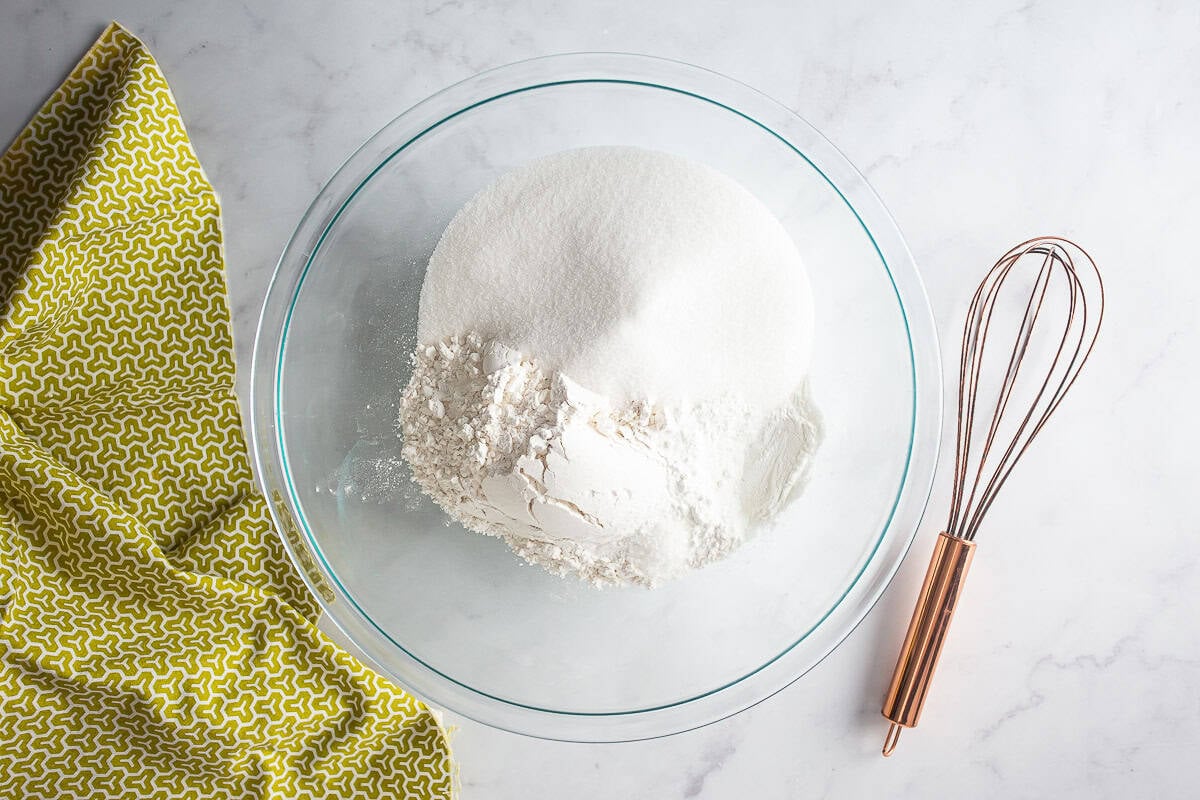 Mixing dry ingredients for chocolate pistachio loaf in a glass bowl.