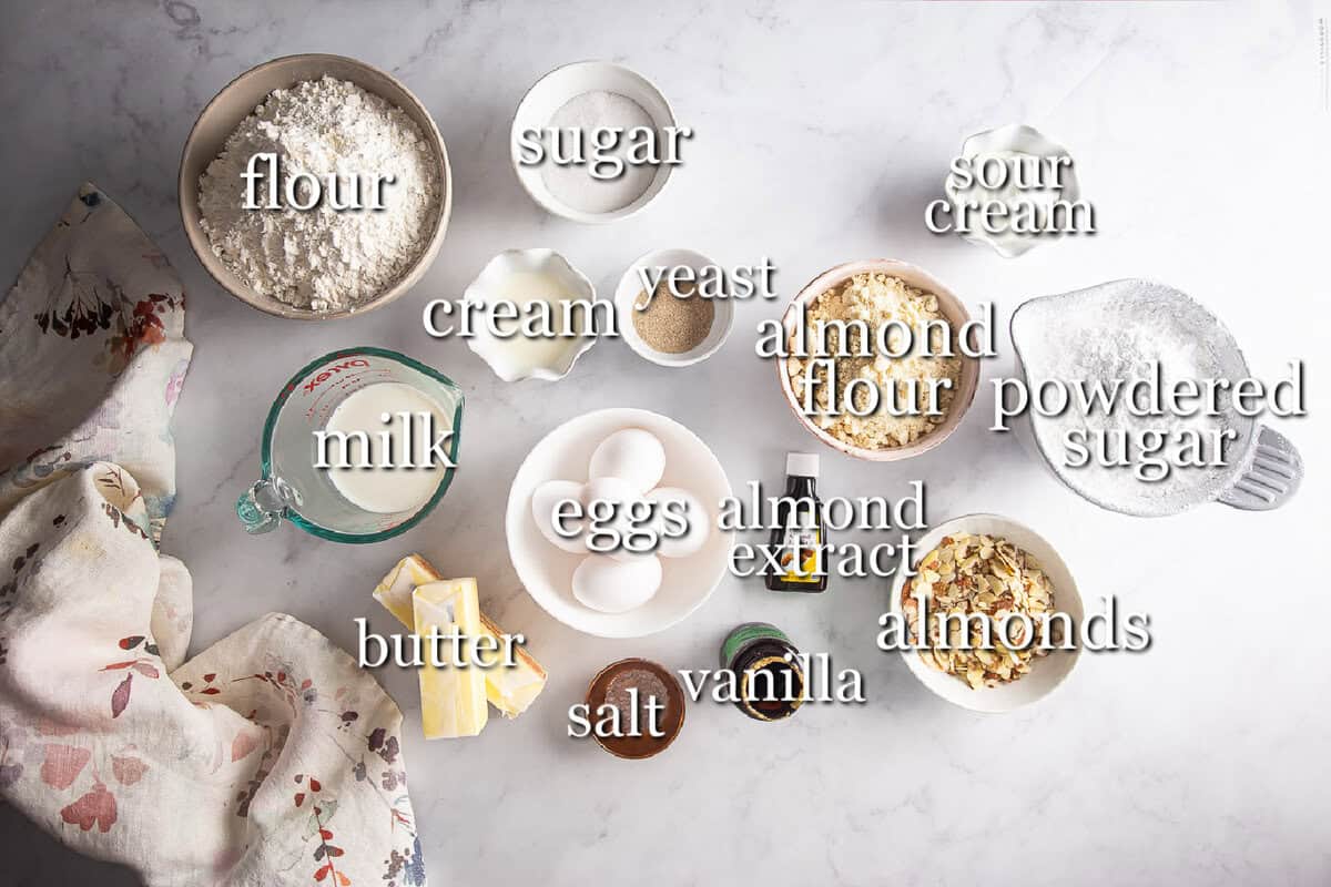 Ingredients for almond rolls in separate containers on a gray background.