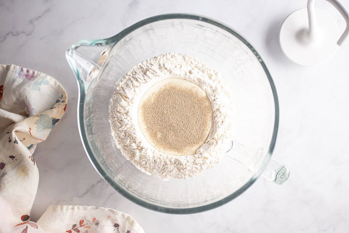 Blooming the yeast for almond rolls in a glass bowl.
