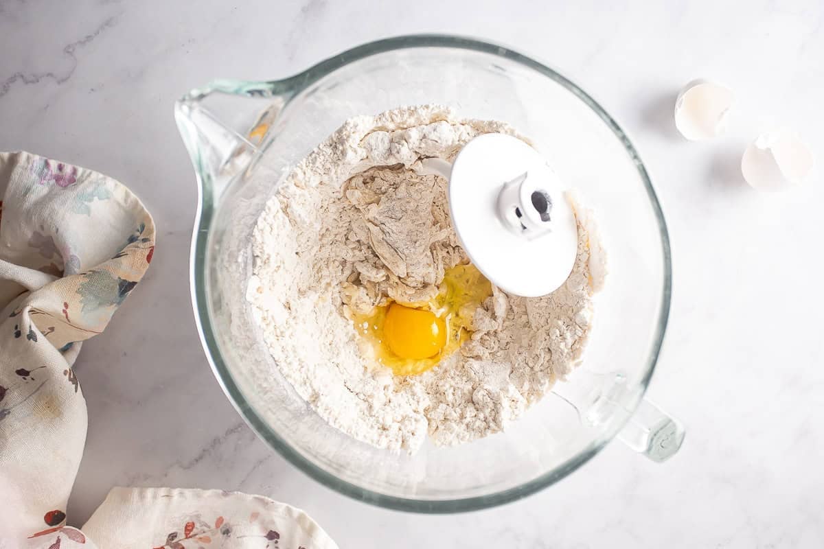 Adding eggs to the almond roll dough.