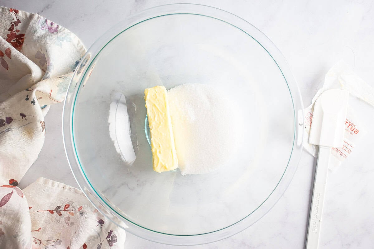 The butter, sugar, and extracts for almond roll filling in a mixing bowl before being mixed.