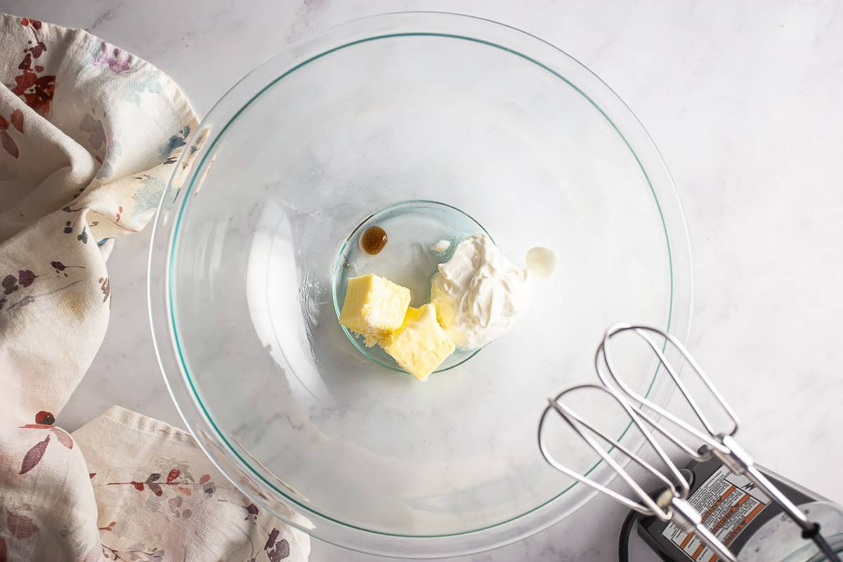 Almond roll icing ingredients, butter, sour cream, and extracts, before being mixed.