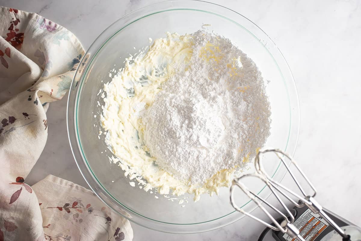 Adding the powdered sugar to the almond roll icing.