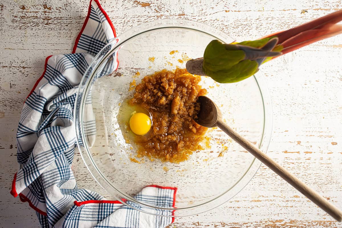 Adding an egg to the butter and sugar mixture.