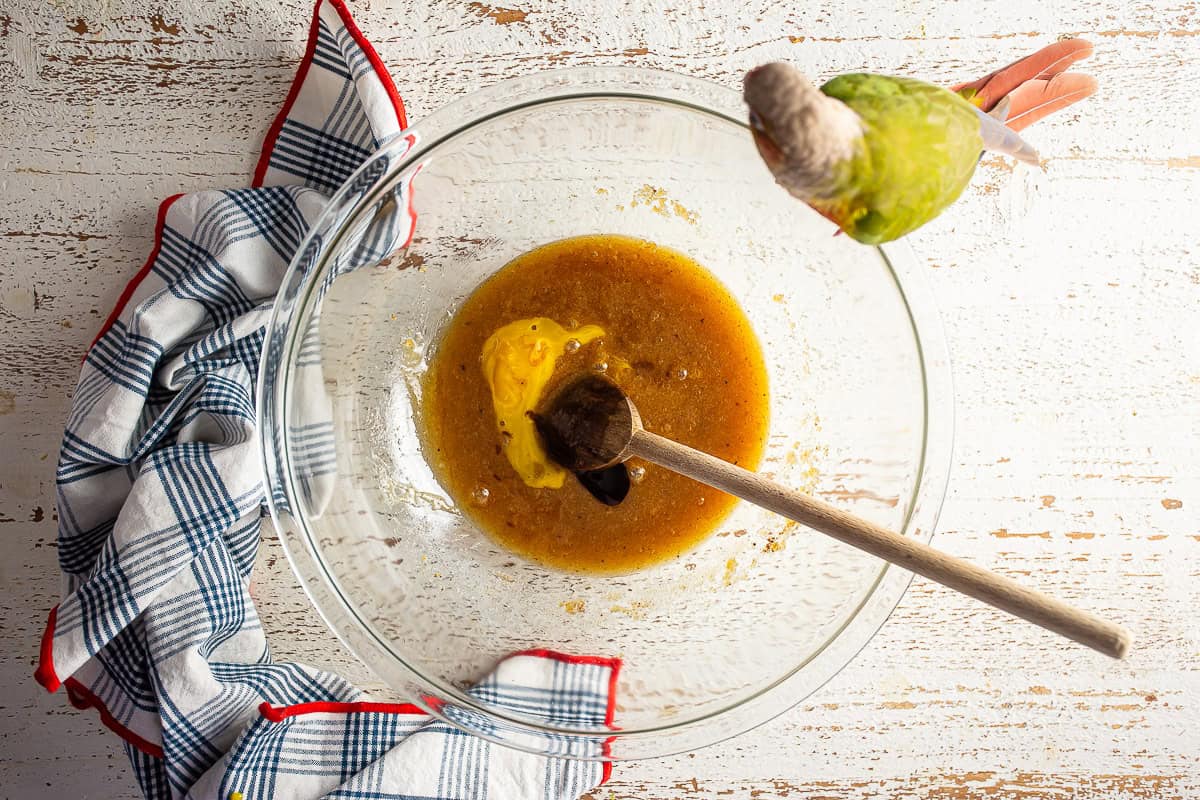 Adding another egg yolk to the bowl with the butter, sugar, and egg.