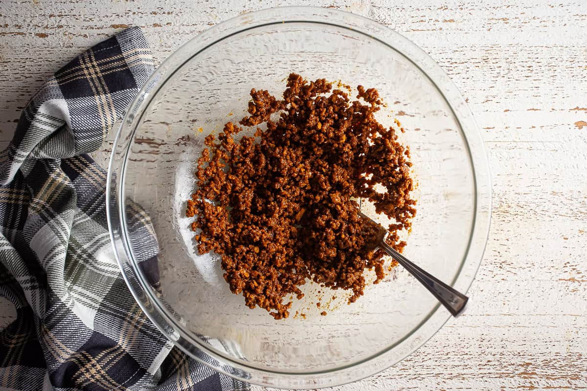 Biscoff cookie crumbs and butter after being mixed but before being pressed.