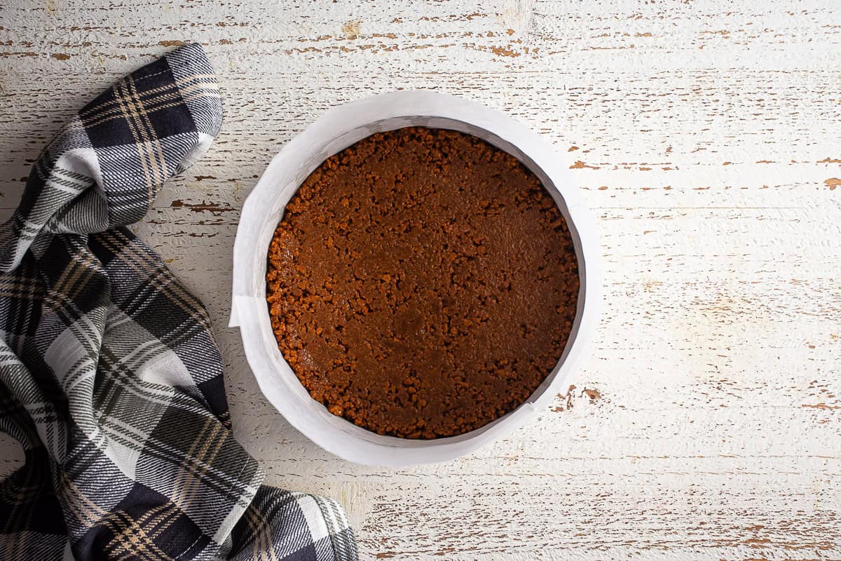 Biscoff cookie crust for cheesecake after being pressed into a prepared pan.