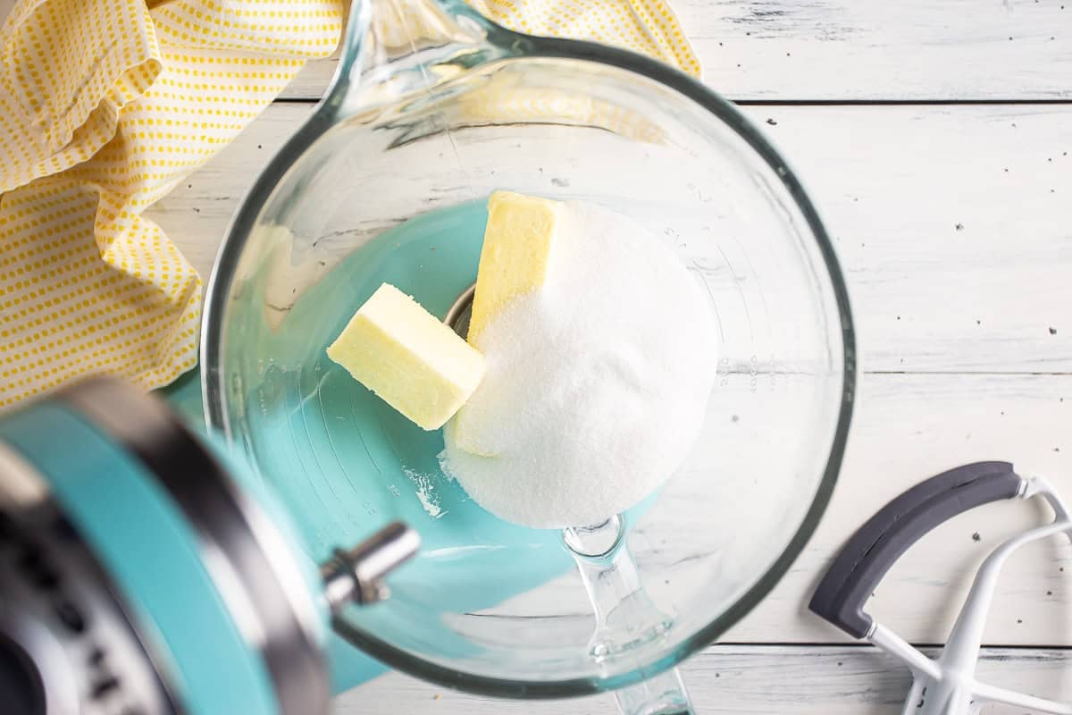 Adding butter and sugar to a mixing bow.