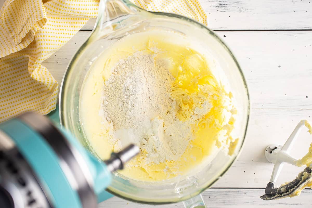 Adding flour to the cookie dough in a mixer.