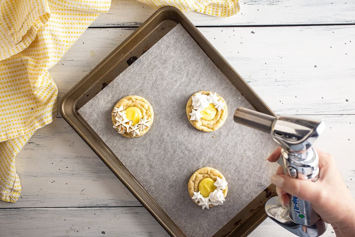 Torching the meringue on the lemon meringue pie cookies.