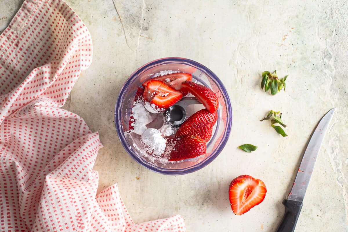 Blending the strawberries and sugar in a food processor.