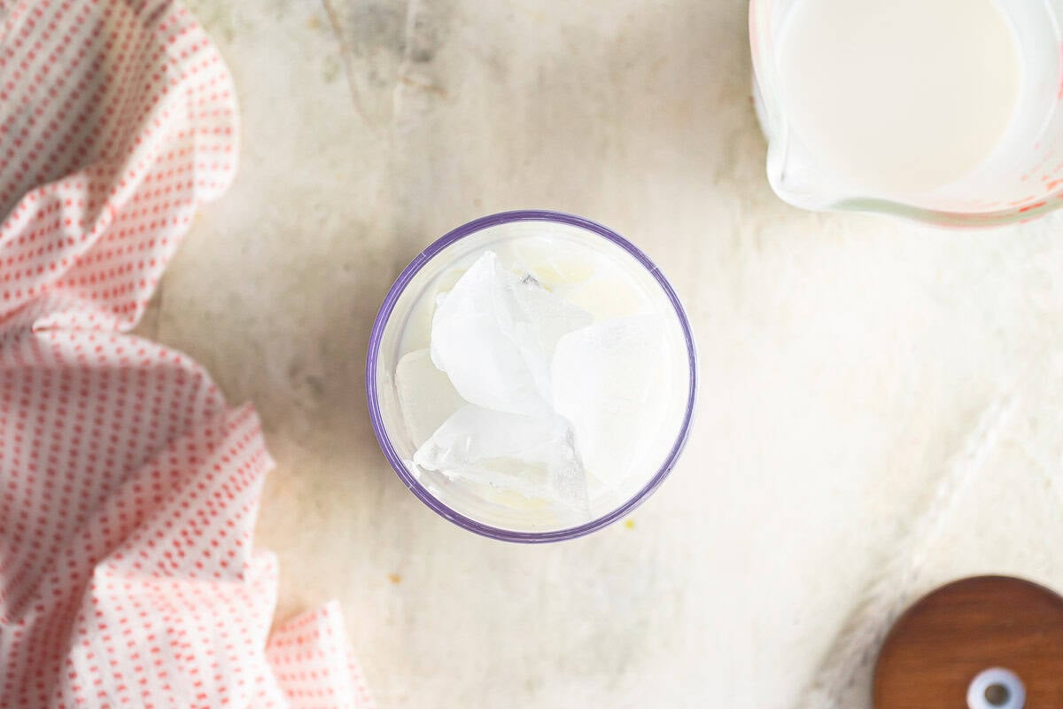 layering milk into a glass for an iced matcha latte