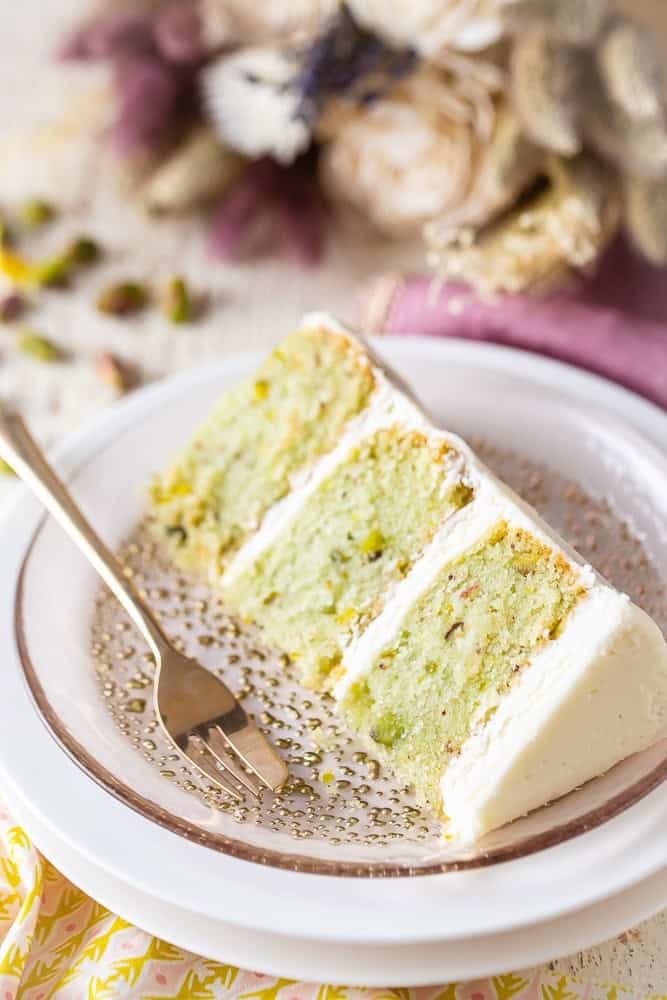 Pistachio cake slice on a plate with a fork