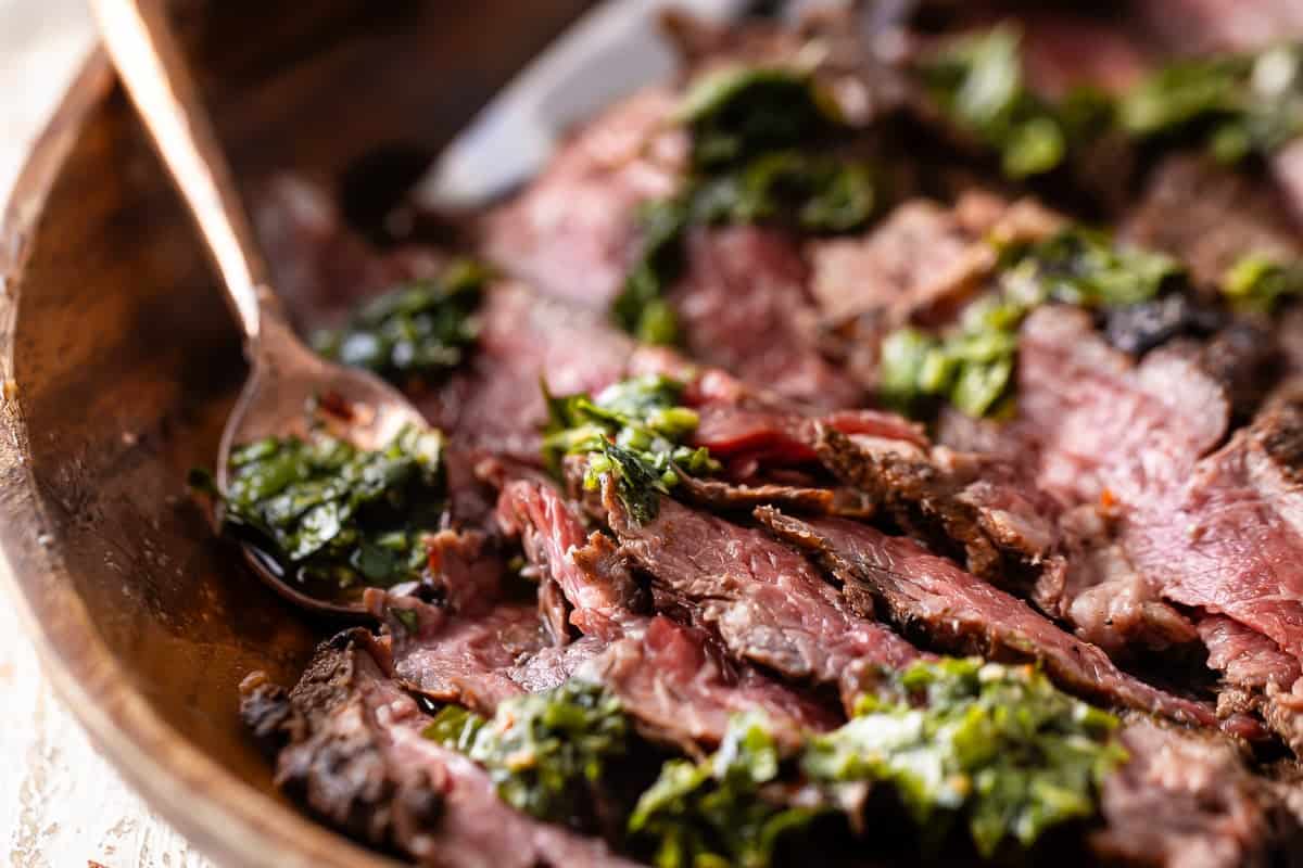 Chimichurri steak in a brown serving dish.
