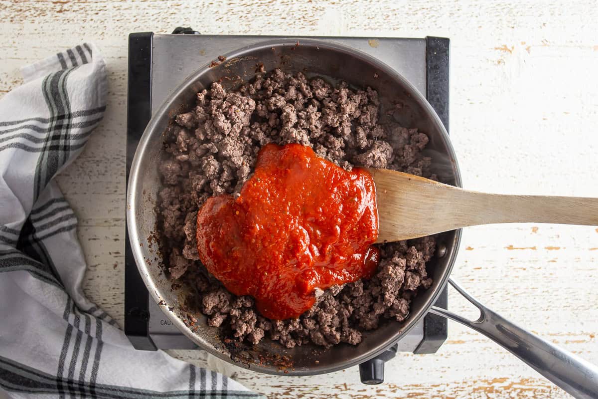 Adding tomato sauce to the meat mixture for stuffed shells