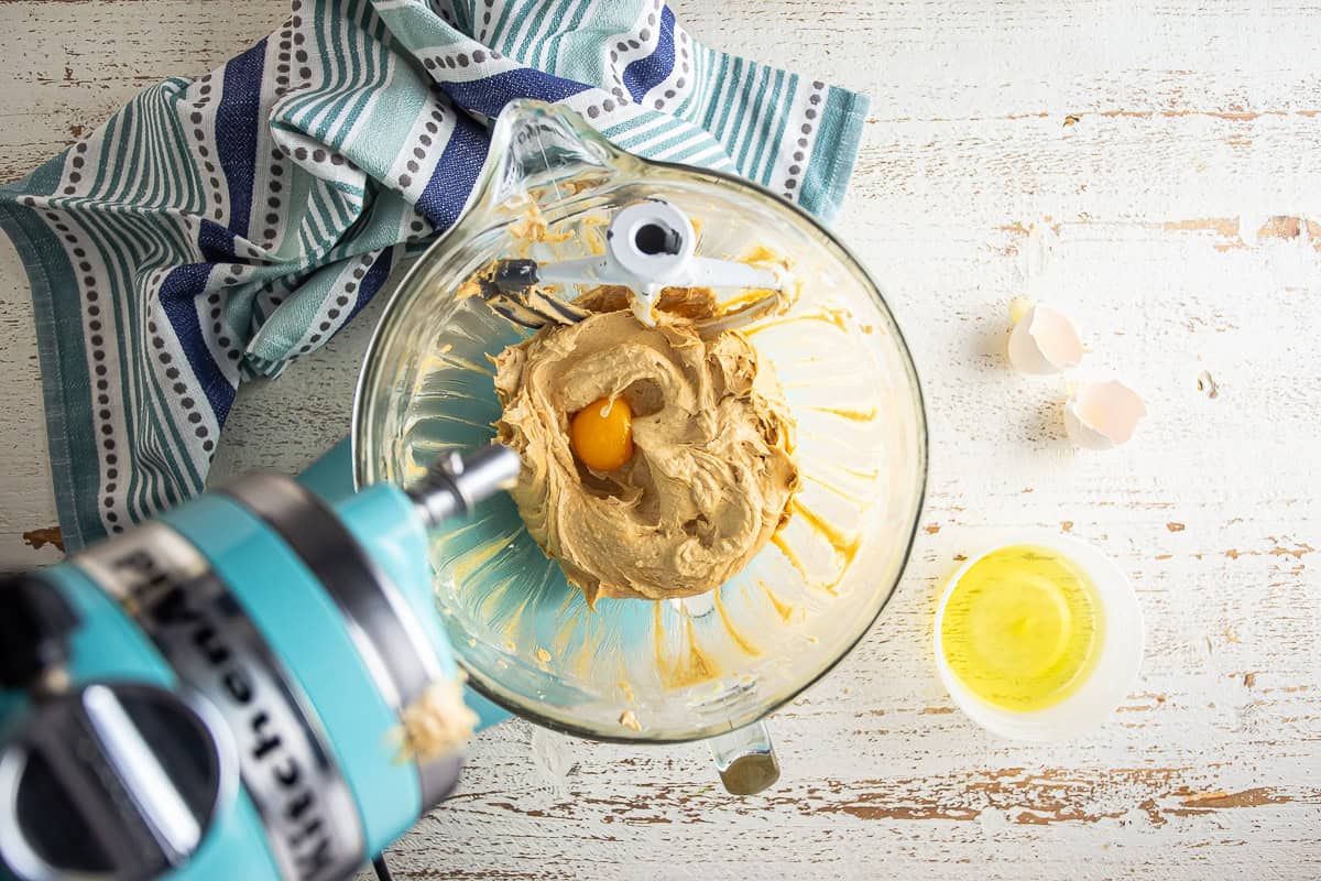 Adding egg yolk to the peanut butter cookie dough.