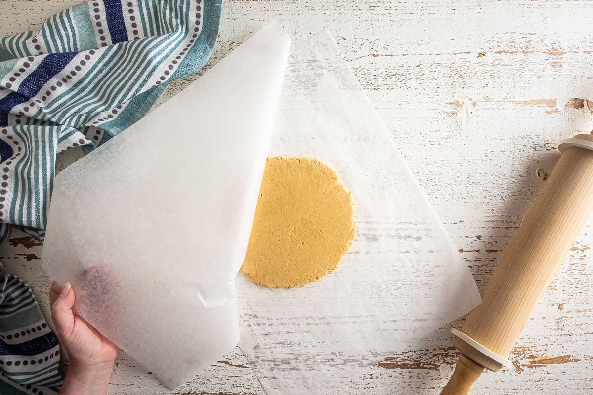 Rolling out cookie dough between parchment sheets