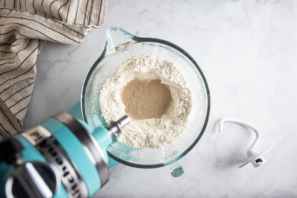 Blooming yeast in a glass mixing bowl for maritozzi.