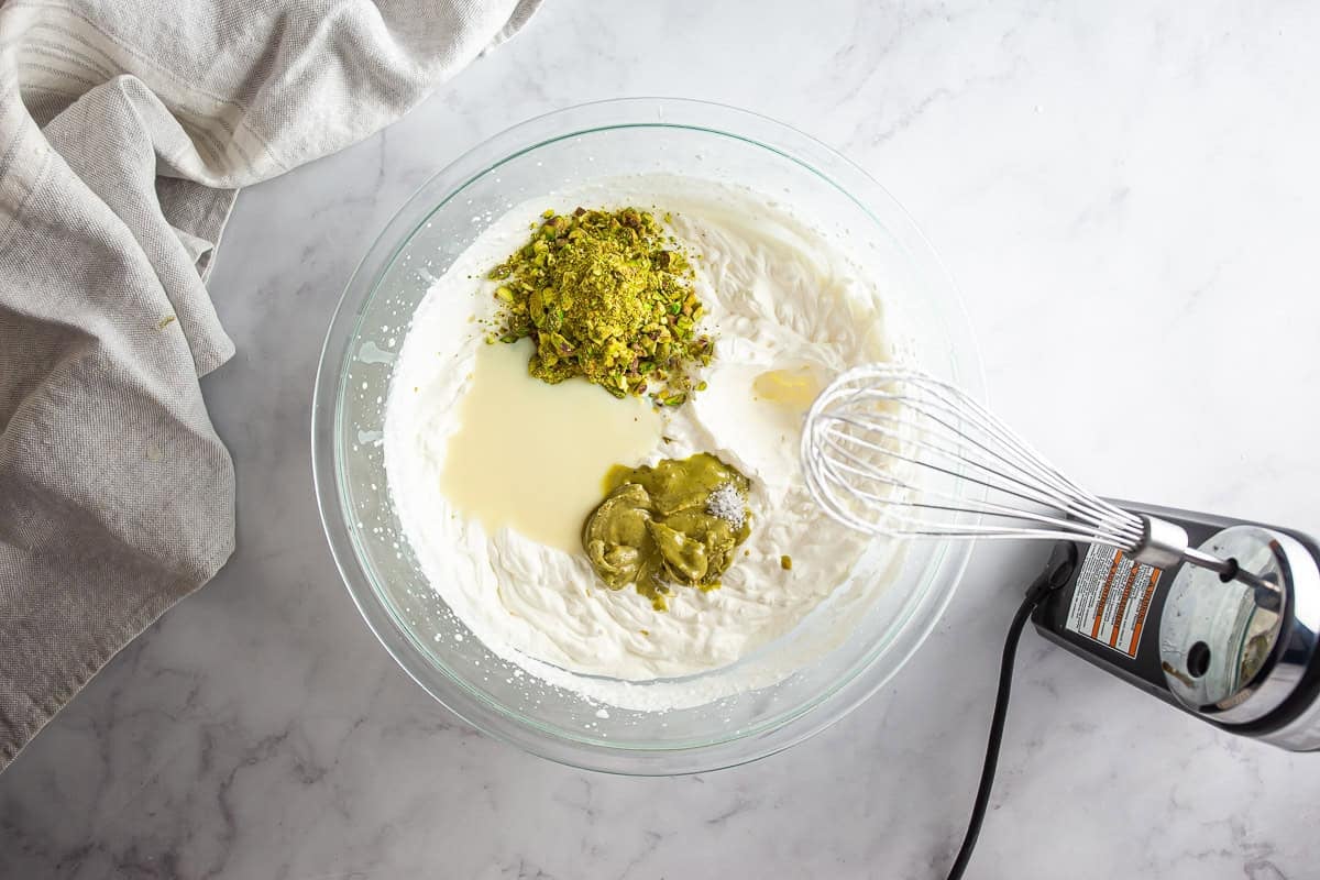 Adding mix-ins to the whipped cream for pistachio ice cream
